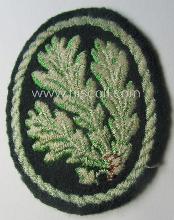 Truly used WH (Heeres) so-called: 'Jäger'-armbadge being a neatly machine-embroidered- and/or multi-coloured version as was executed on darker-green-coloured 'felt-based'-wool