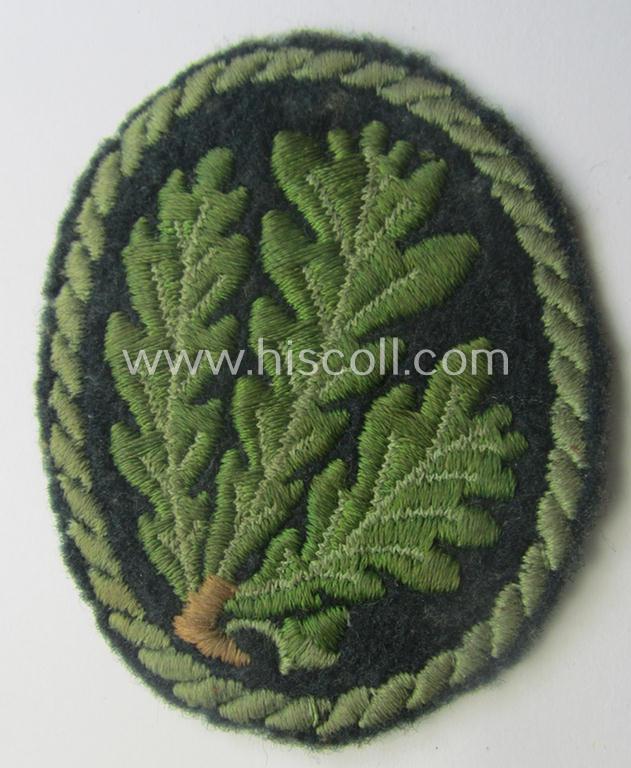 Truly used WH (Heeres) so-called: 'Jäger'-armbadge being a neatly machine-embroidered- and/or multi-coloured version as was executed on darker-green-coloured 'felt-based'-wool