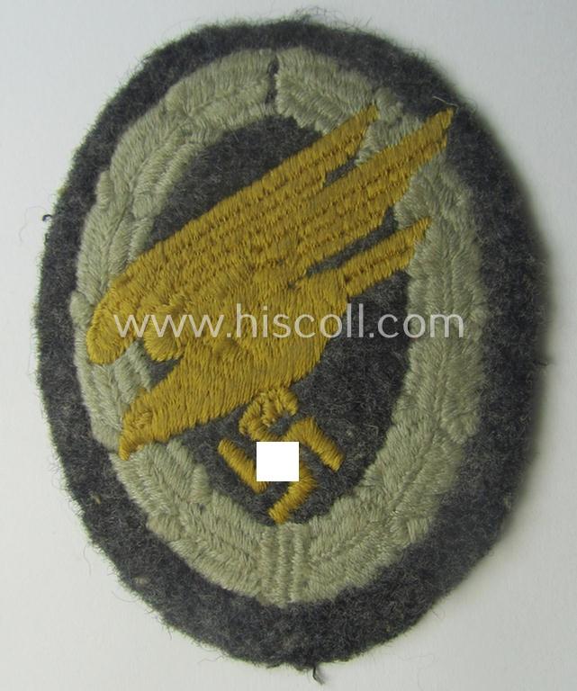 WH (Luftwaffe) 'Fallschirmschützen-Abzeichen in Stoff' (or: cloth-based paratroopers'-jump-badge) being a nicely machine-embroidered specimen that comes in a just moderately used- ie. carefully tunic-removed, condition