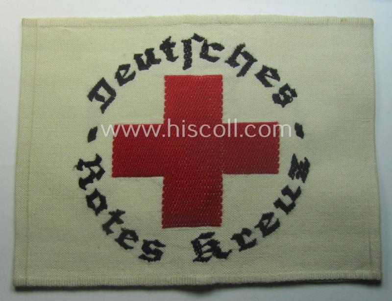 Linnen-based- and/or neatly 'machine-embroidered', beige-white-coloured DRK- (ie. 'Deutsches Rotes Kreuz'-) armband (ie. 'Armbinde') as was intended for the staff-members serving with the: 'Deutsches Rotes Kreuz' (or: German Red Cross)