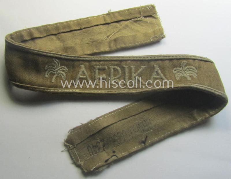 WH cuff-title (ie. 'Ärmelstreifen') entitled: 'Afrika' (being an example that bears a printed 'RbN.'-numeral ('RBN.0/0250/2340') and that comes in an issued, clearly worn- and/or most certainly once tunic-attached, condition)