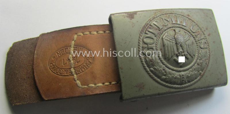 Minimally used, WH (Heeres) field-grey-coloured- and/or steel-based belt-buckle being a clearly maker-marked example that comes mounted onto its maker- (ie. 'Schmöle & Comp - Menden'-) marked and/or '1941'-dated leather-based tab