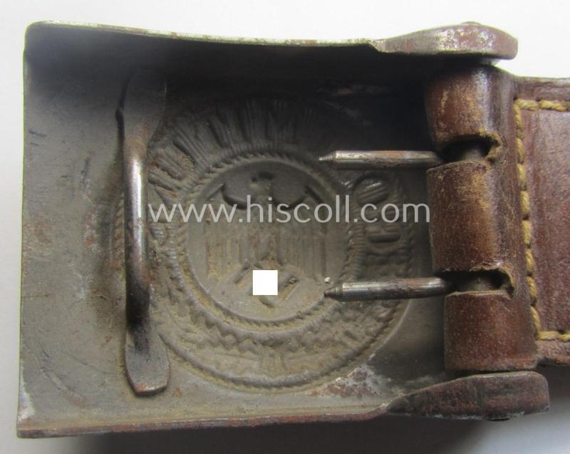 Moderately used, WH (Heeres) field-grey-coloured- and/or steel-based belt-buckle being a non-maker-marked example that comes mounted onto its maker- (ie. 'F.W. Assmann - Lüdenscheid'-) marked and/or '1940'-dated leather-based tab