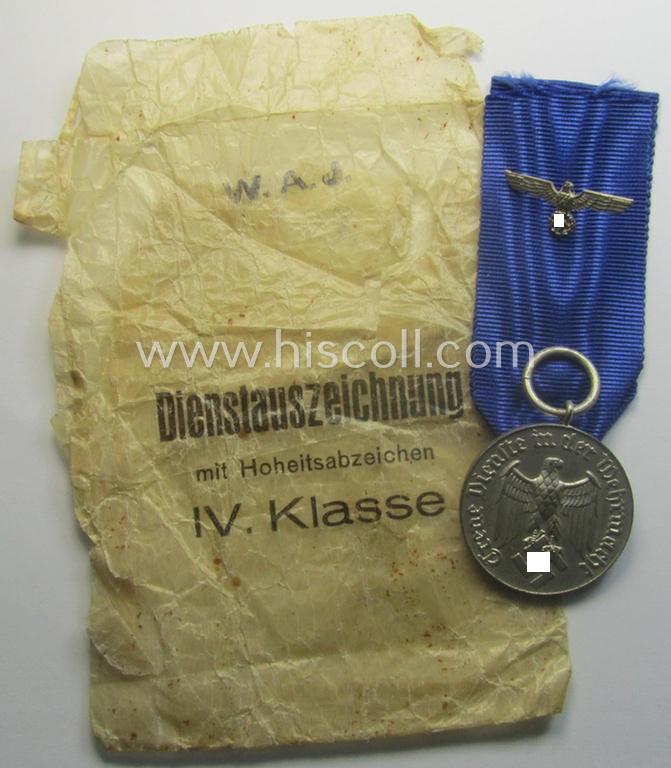 WH (Heeres o. KM) bright-silver-toned, 'WH-DA der 4. Klasse für 4 Jahre Dienstzeit' that comes with its accompanying ribbon (ie. 'Bandabschnitt') and eagle-device as stored in its period 'Cellophan'-based pouch